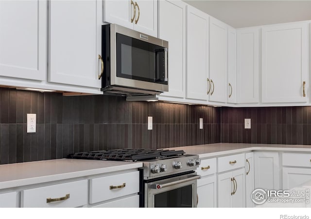 kitchen featuring appliances with stainless steel finishes, tasteful backsplash, and white cabinetry