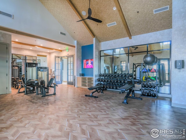 workout area featuring parquet flooring, ceiling fan, and a towering ceiling