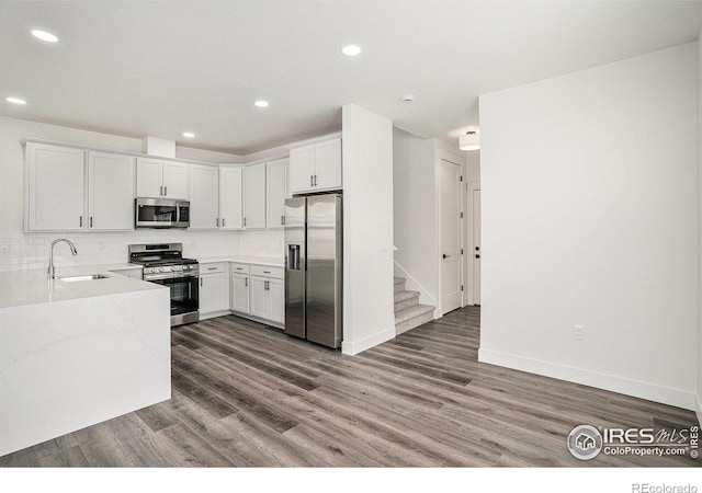 kitchen featuring stainless steel appliances, white cabinetry, sink, and dark wood-type flooring