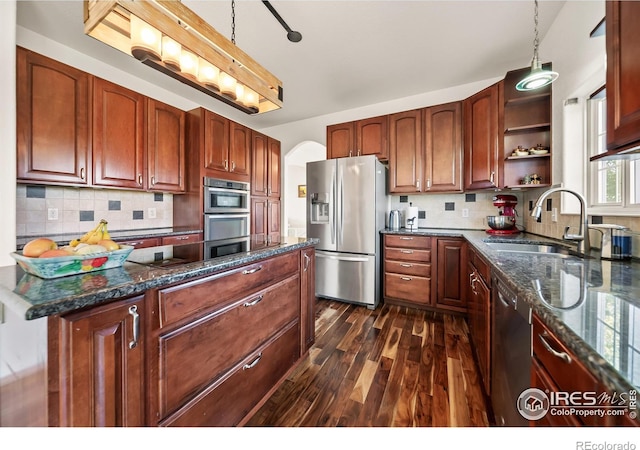 kitchen with tasteful backsplash, pendant lighting, dark hardwood / wood-style floors, and stainless steel appliances