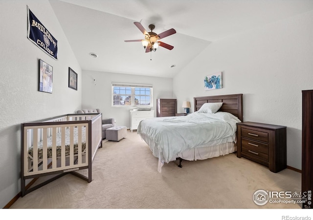 carpeted bedroom with vaulted ceiling and ceiling fan