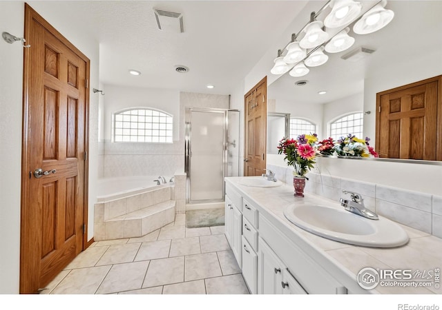 bathroom featuring vanity, tile patterned flooring, and plus walk in shower