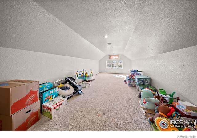 recreation room featuring a textured ceiling, vaulted ceiling, and carpet floors