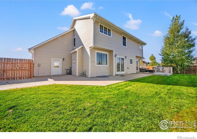 rear view of house featuring a yard and a patio area