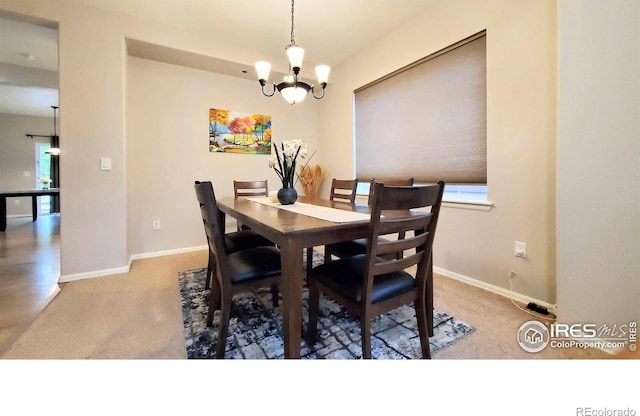 dining area with a chandelier and carpet