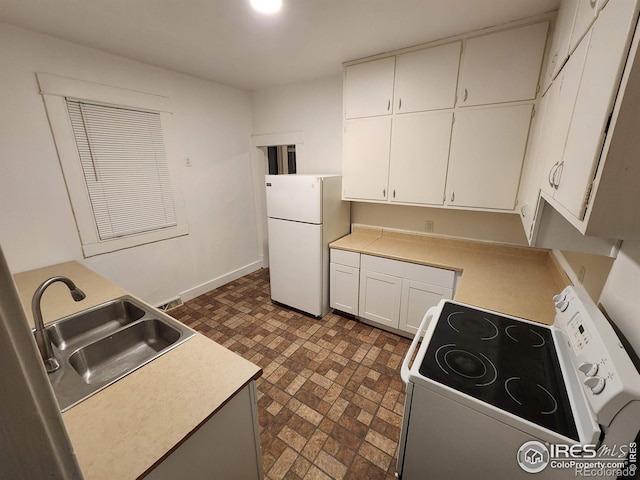 kitchen with light countertops, white appliances, a sink, and white cabinetry