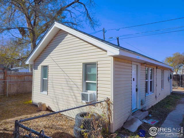 view of property exterior with cooling unit and fence