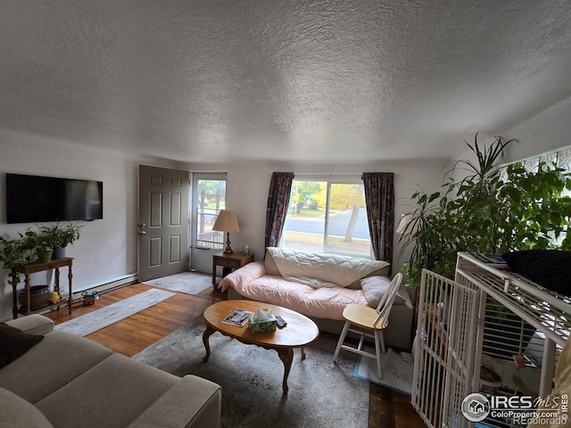 living room featuring baseboard heating, a textured ceiling, and hardwood / wood-style flooring