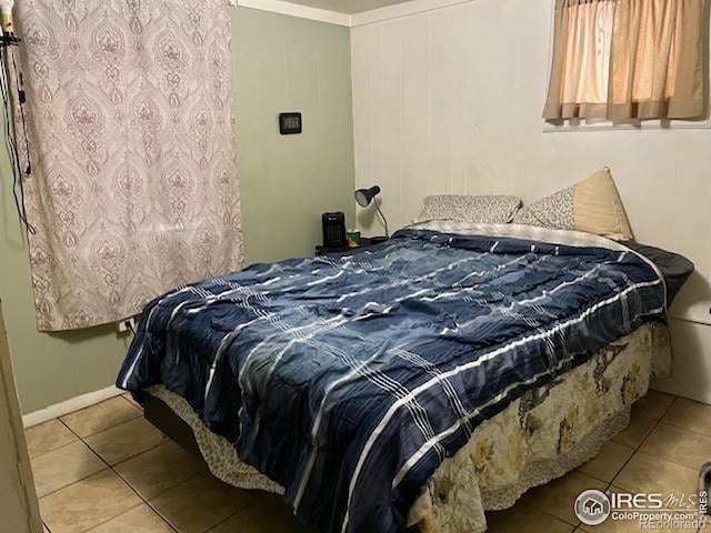 bedroom with light tile patterned flooring and crown molding