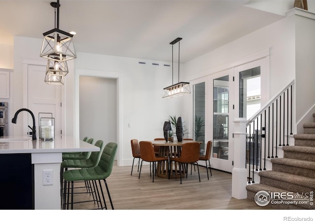 dining room featuring sink and light hardwood / wood-style floors