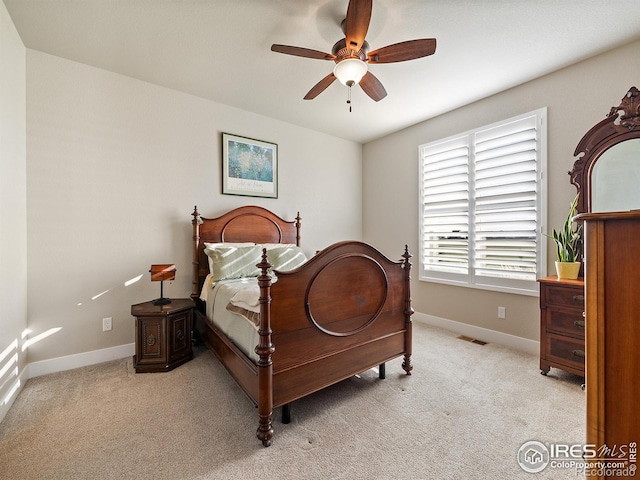 bedroom featuring a ceiling fan, light carpet, and baseboards