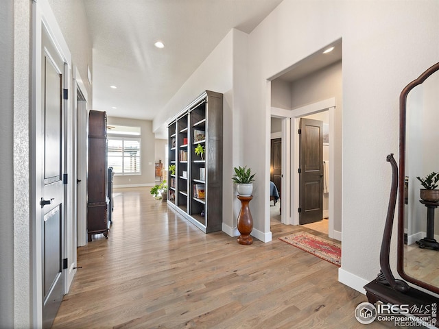 corridor with light wood-style floors, recessed lighting, and baseboards