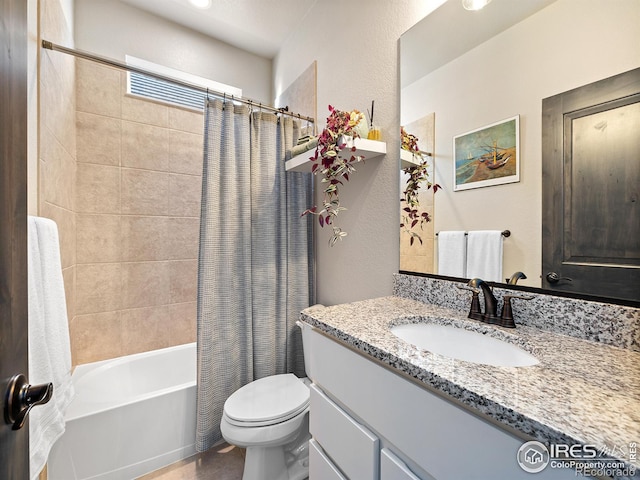 bathroom with a textured wall, shower / bath combo, vanity, and toilet