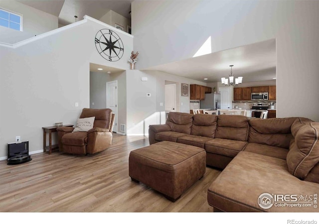 living room featuring a notable chandelier and light wood-type flooring