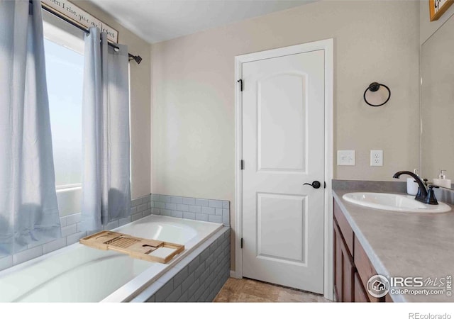 bathroom with vanity and tiled tub