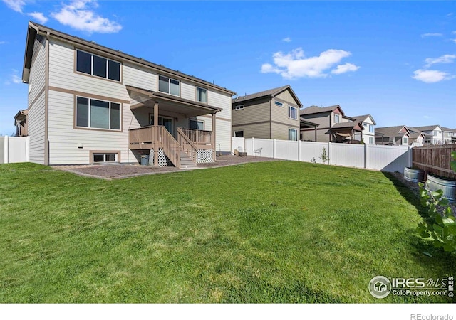 rear view of house featuring a lawn, a patio, and a deck