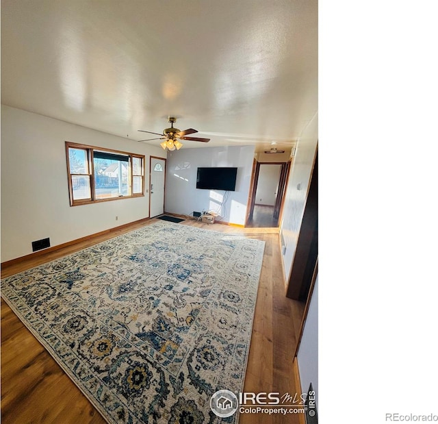 living room featuring hardwood / wood-style flooring and ceiling fan