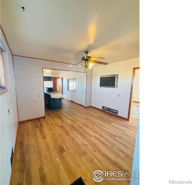 180 W 3rd St S, Cheyenne Wells, CO 80810 - unfurnished living room with light wood-style flooring and ceiling fan