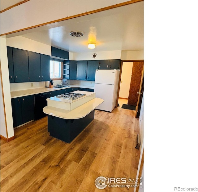 180 W 3rd St S, Cheyenne Wells, CO 80810 - kitchen with freestanding refrigerator, light wood finished floors, light countertops, stainless steel cooktop, and a center island