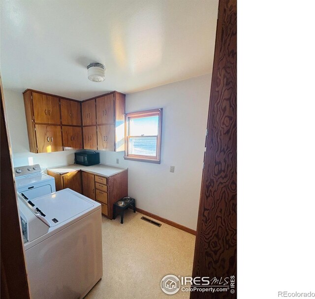 180 W 3rd St S, Cheyenne Wells, CO 80810 - laundry room with cabinet space, washing machine and clothes dryer, and light colored carpet