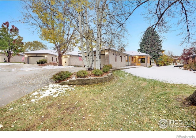 ranch-style home featuring a garage and a front lawn