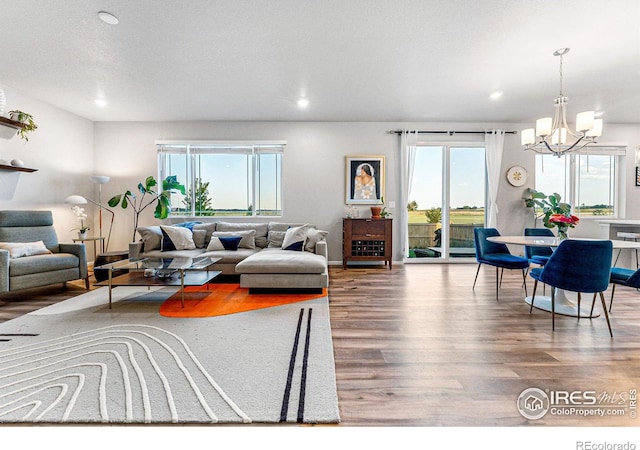 living room featuring an inviting chandelier, wood-type flooring, and a wealth of natural light