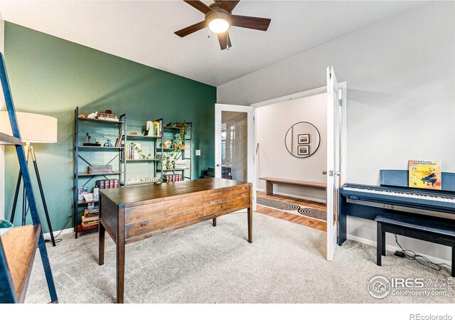 carpeted home office featuring ceiling fan