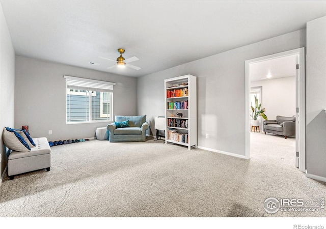 living area featuring carpet and ceiling fan