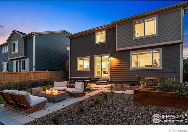 back house at dusk with a patio and an outdoor fire pit