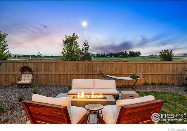 patio terrace at dusk featuring an outdoor fire pit