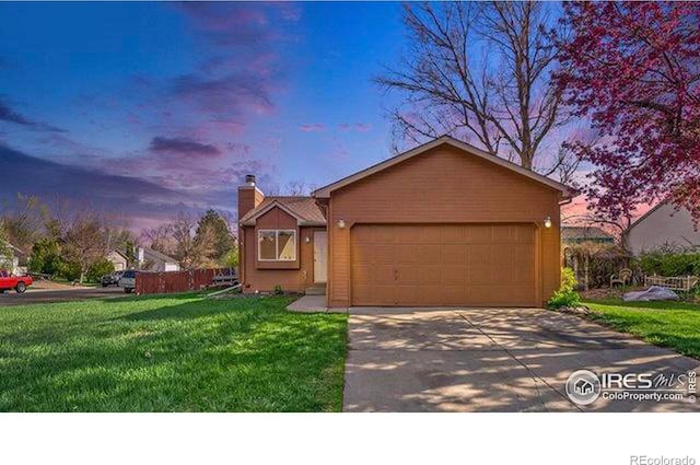 view of front of property with a garage and a yard