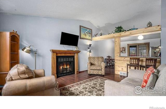 living room featuring dark hardwood / wood-style floors and vaulted ceiling