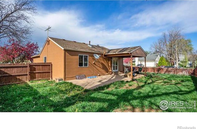 rear view of property featuring a patio area and a yard