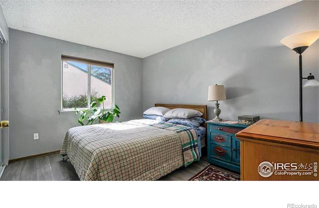 bedroom featuring hardwood / wood-style floors and a textured ceiling