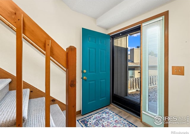 entryway with hardwood / wood-style floors and a textured ceiling