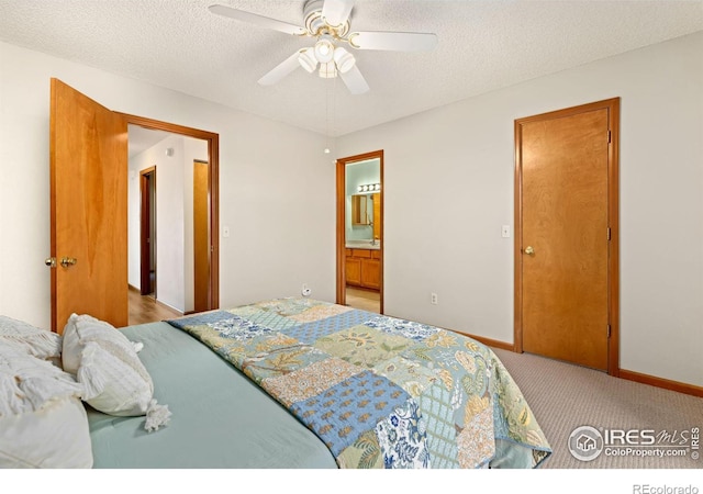 bedroom featuring a textured ceiling, light carpet, ceiling fan, and ensuite bathroom