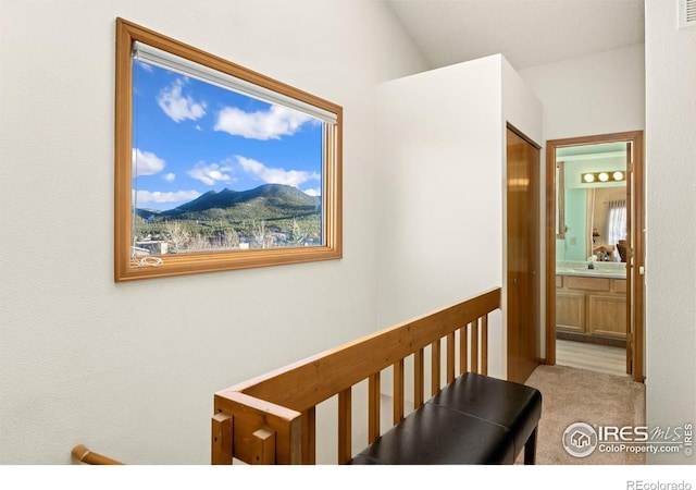 corridor featuring a mountain view, light carpet, sink, and vaulted ceiling