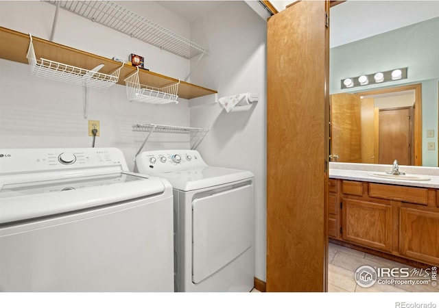 washroom featuring light tile patterned flooring, sink, and separate washer and dryer