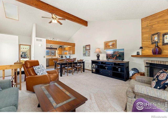 carpeted living room featuring wooden walls, high vaulted ceiling, ceiling fan, beam ceiling, and a fireplace