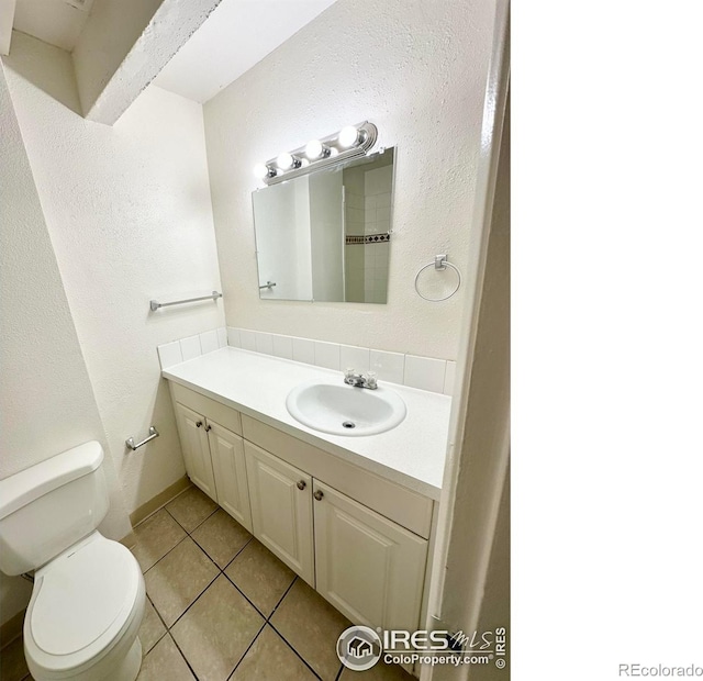 bathroom featuring toilet, vanity, and tile patterned floors