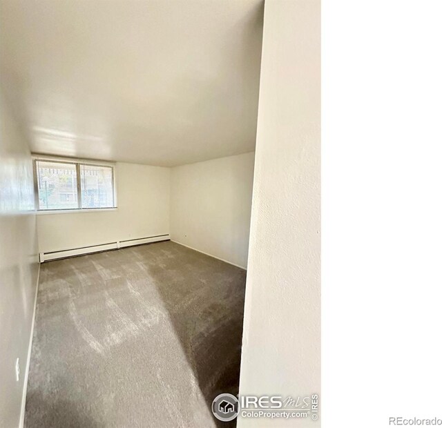 empty room with baseboard heating and carpet flooring