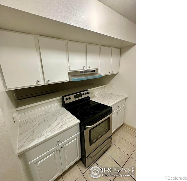 kitchen featuring stainless steel range with electric stovetop, white cabinets, and light tile patterned floors