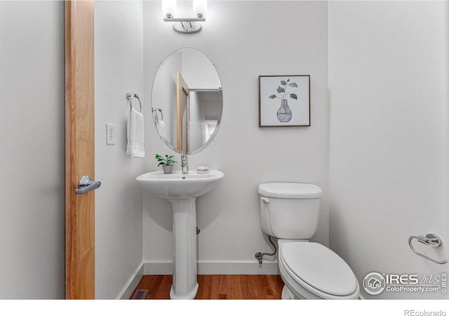 bathroom featuring sink, wood-type flooring, and toilet