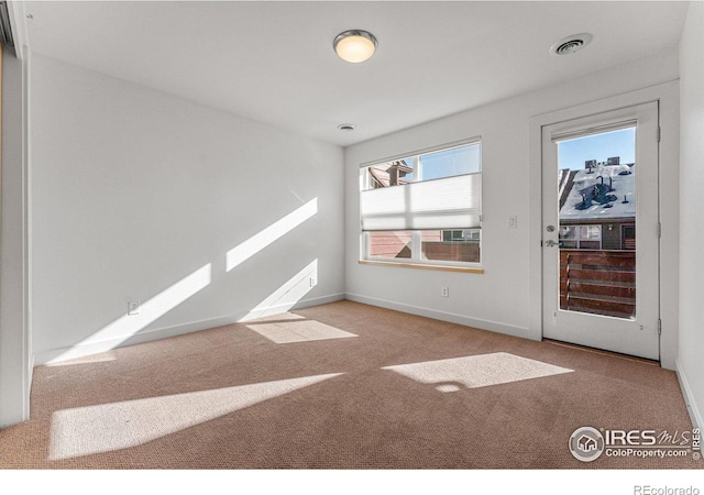 unfurnished room featuring light carpet