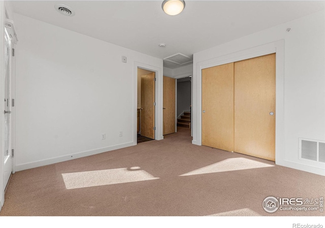 unfurnished bedroom featuring carpet flooring and a closet