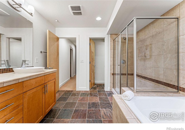 bathroom with vanity and independent shower and bath