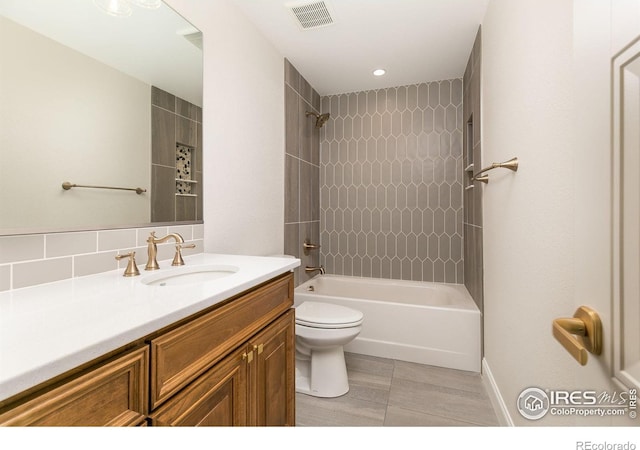 full bathroom with vanity, tiled shower / bath combo, and toilet