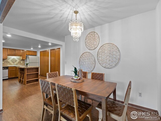 dining space with a chandelier and light hardwood / wood-style floors