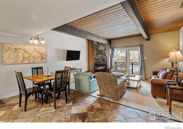 living room featuring beamed ceiling, an inviting chandelier, wooden ceiling, and a fireplace