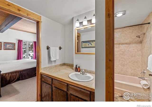 bathroom with tiled shower / bath and vanity